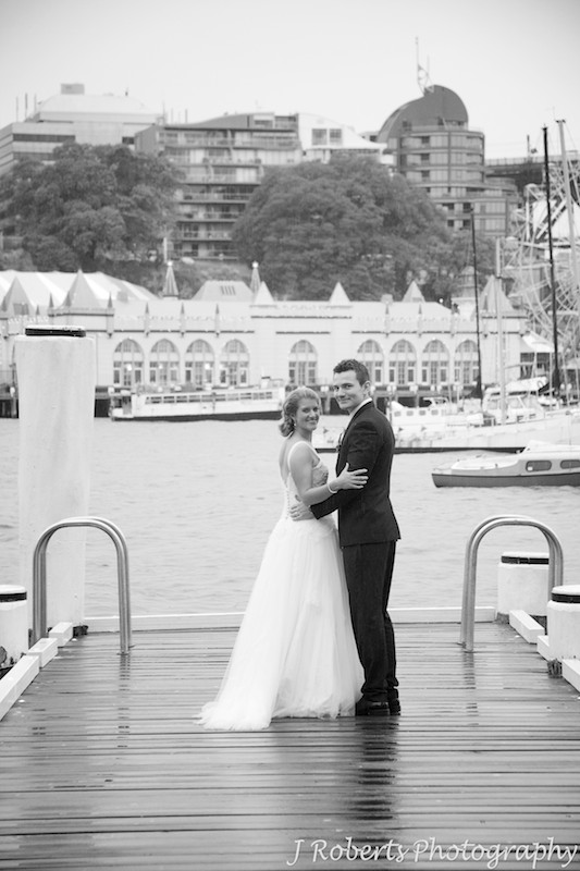 Couple walking on a pier and looking back at the camera - wedding photography sydney